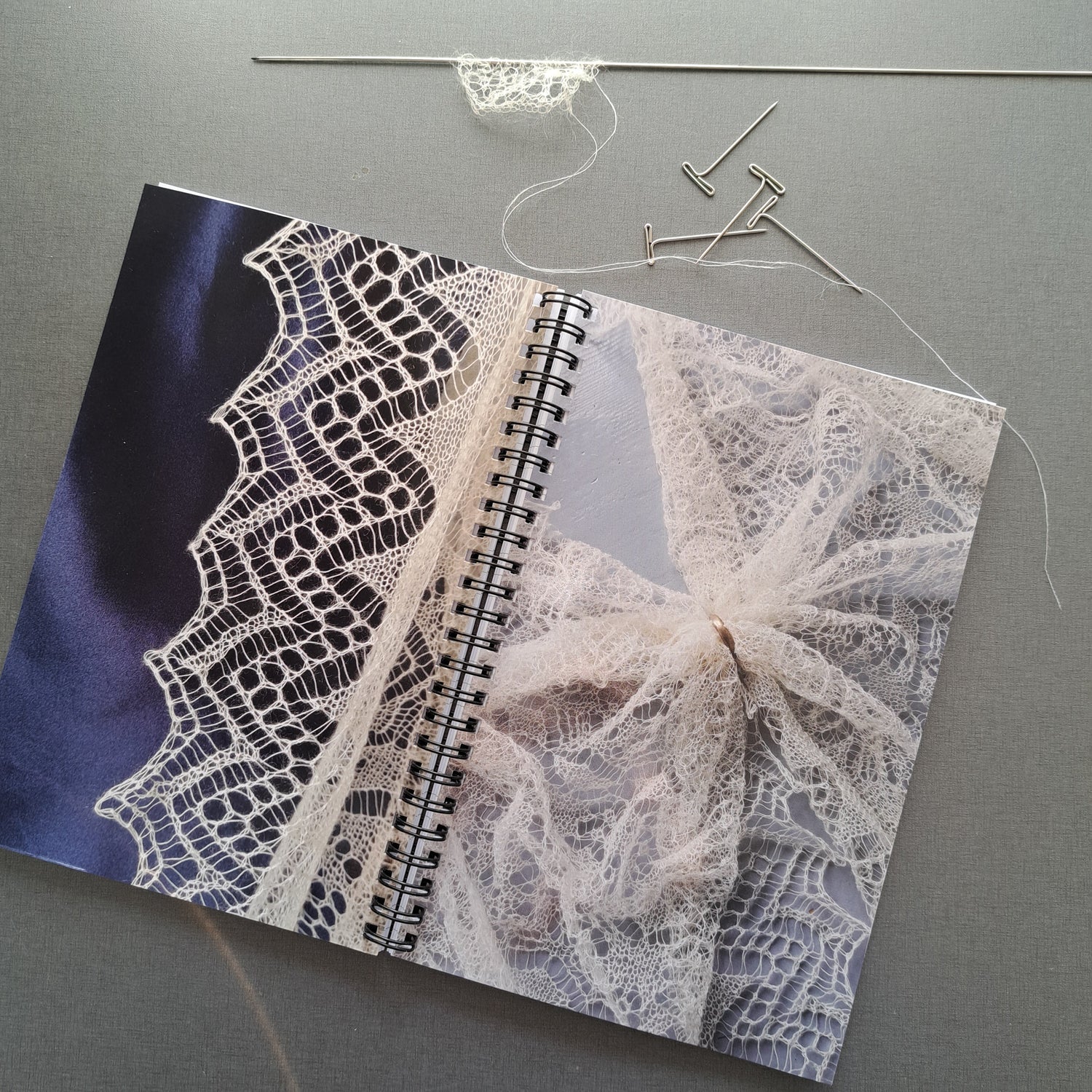 Notebook in red with blue pen and a tea mug on a grey surface